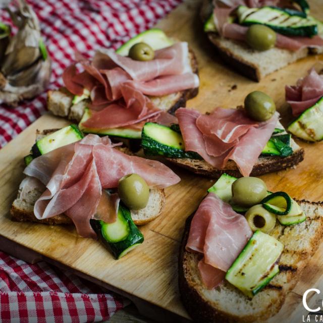 Bruschette con zucchine, crudo e olive